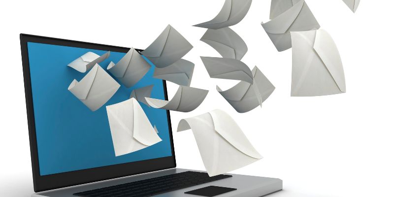 Image of laptop and many envelopes that fly around it